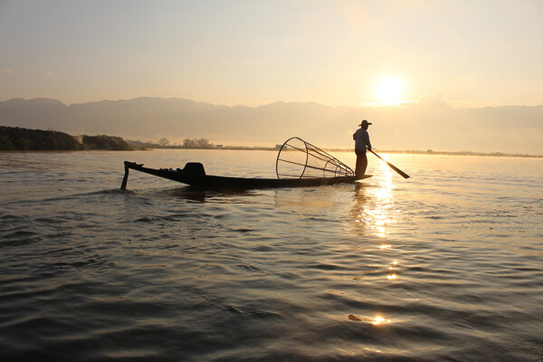 迎着阳光在打渔的渔民