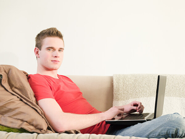 外国男人躺在沙发上玩电脑图片