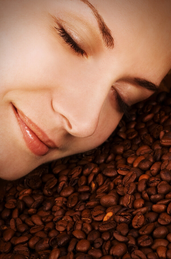 睡在咖啡豆上的美女面部特写图片
