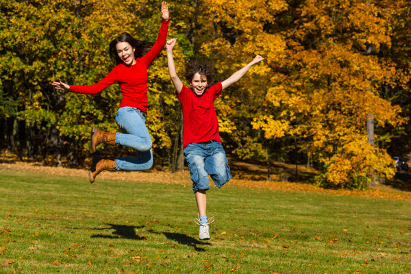 秋天草地风景与跳跃的青少年图片