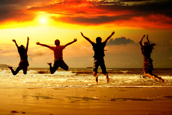 大海沙滩上跃起的四个人图片