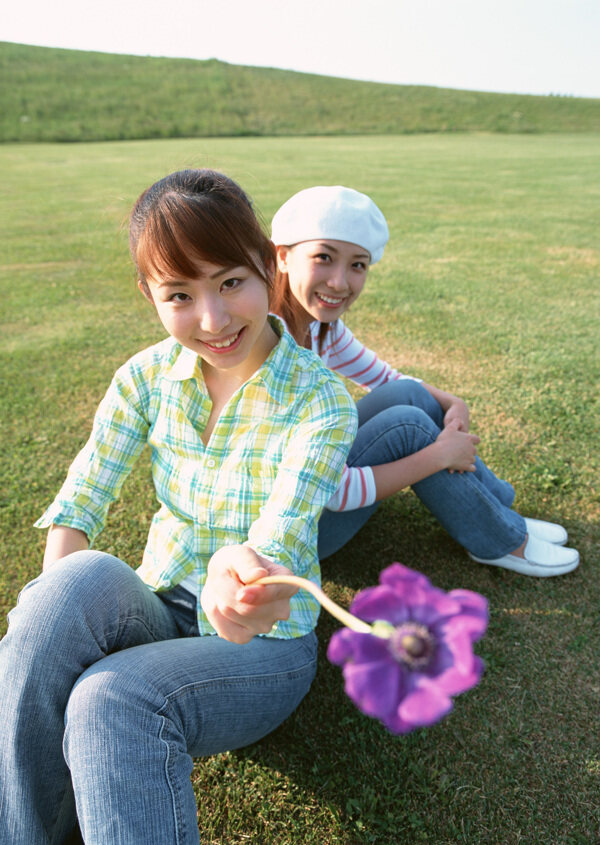 坐在草地上的两个休闲美女图片