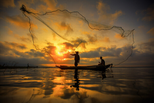 海面上撒网的渔民图片