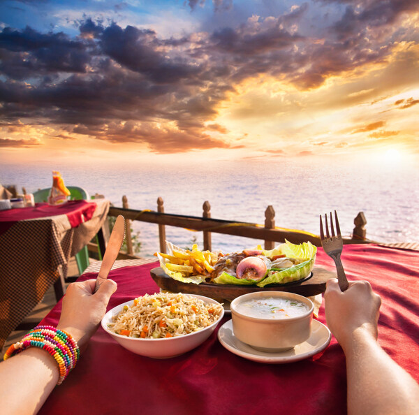 海边餐桌上的双手和美食图片