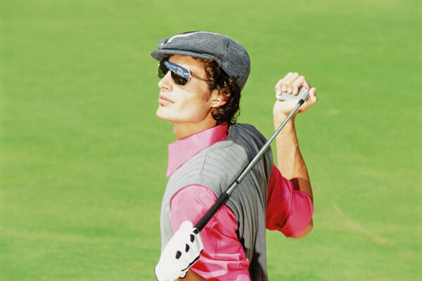 手握高尔夫球杆的时尚男性图片