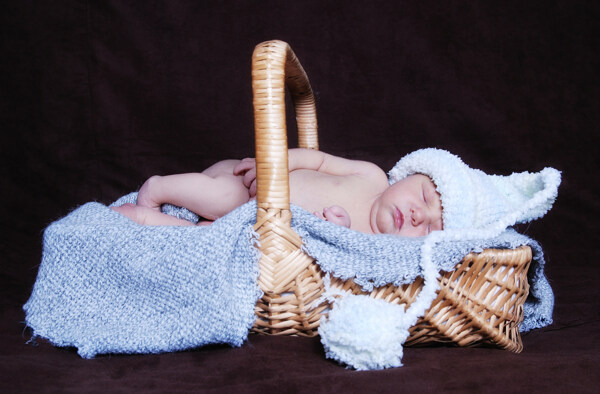 篮子里戴着帽子熟睡的新生宝宝图片
