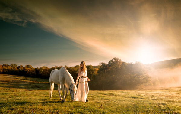 草原上牵马的美女图片