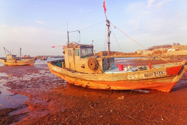 退潮后停泊的木渔船图片