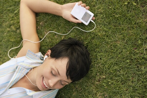 躺在草地上听音乐的美女图片
