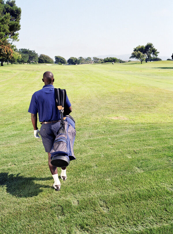 背着高尔夫球具的男人背影图片