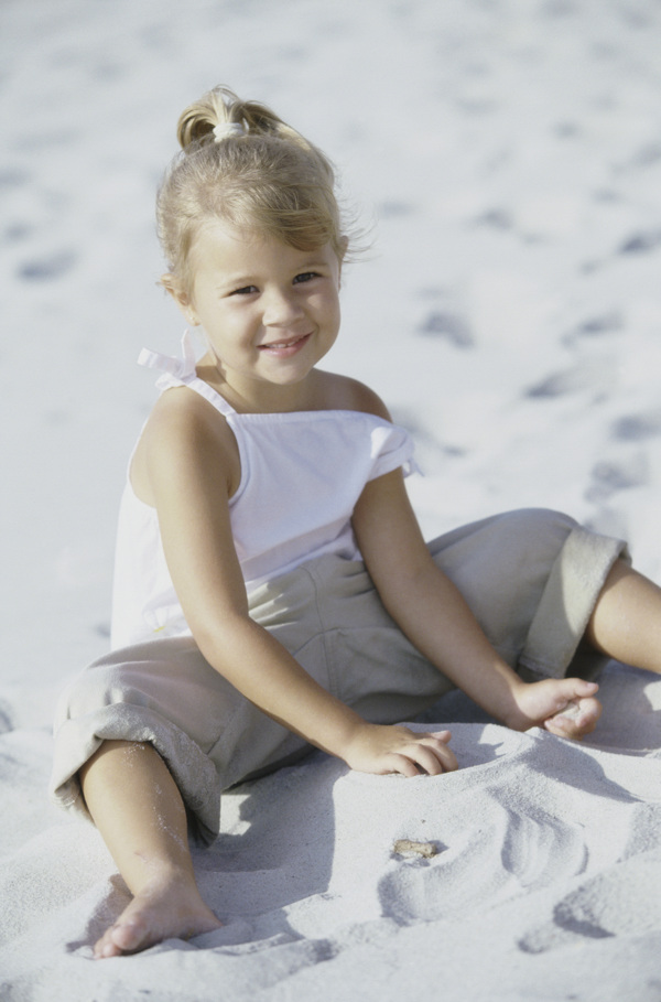 沙滩上玩沙子的小女孩图片