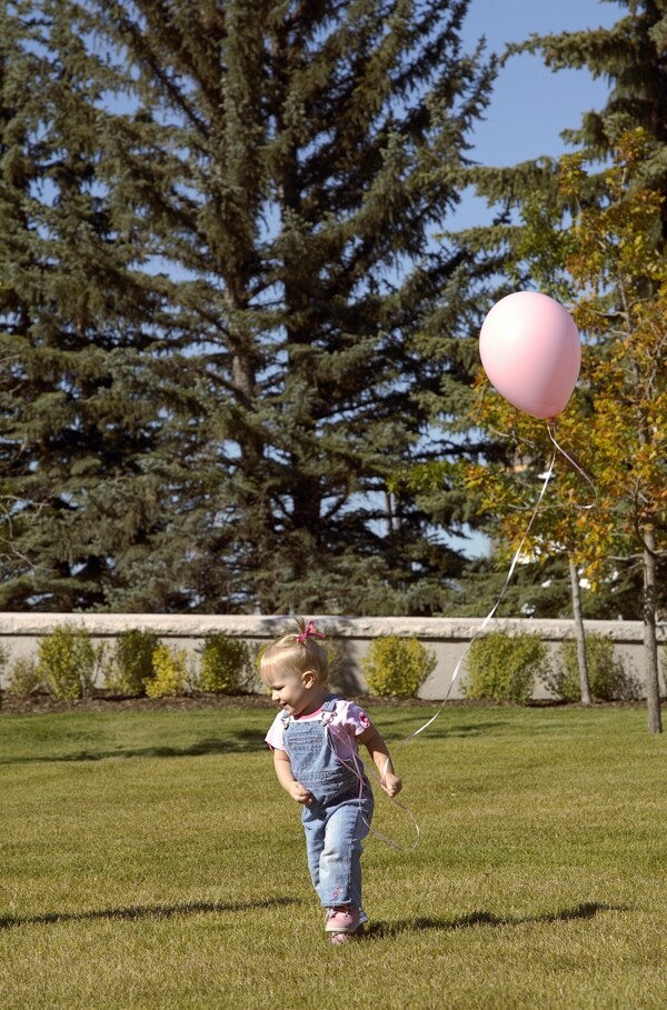 草地上拿着气球的女孩图片