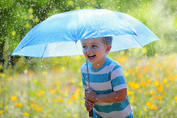 在雨中撑着伞的小男孩图片