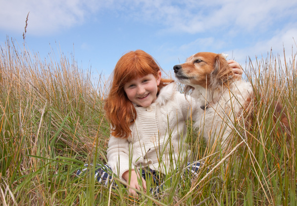 草丛中的小女孩与宠物狗图片