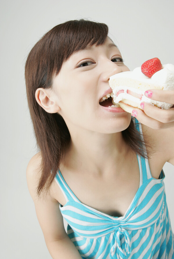 正在吃草莓蛋糕的少女图片