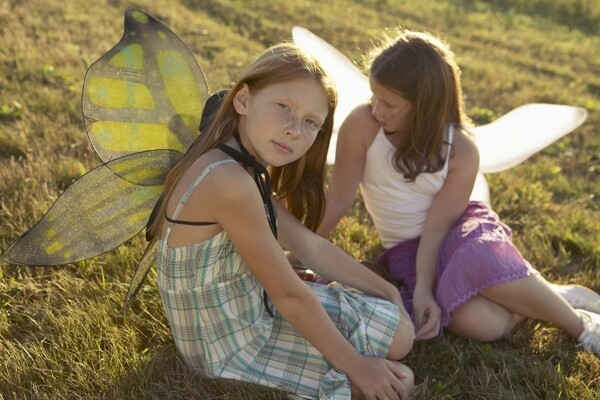 草地上披着翅膀的两个孩子图片