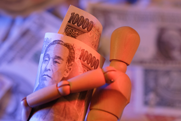 木偶人抱着的日元钞票特写图片