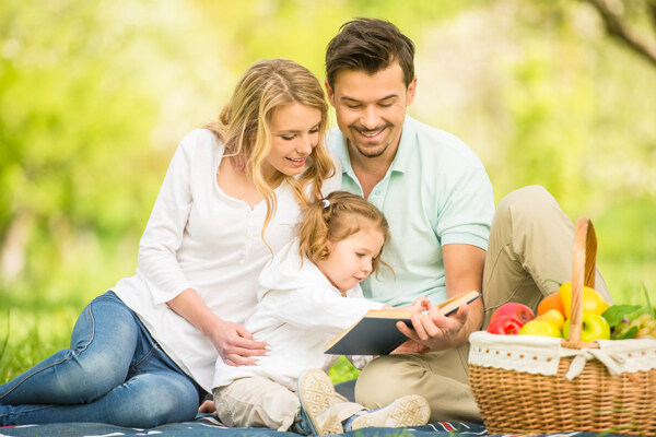 草坪上看书的幸福家庭图片