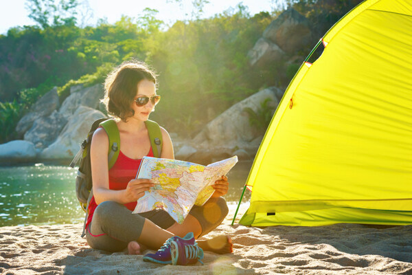 坐在帐篷旁看地图的美女图片