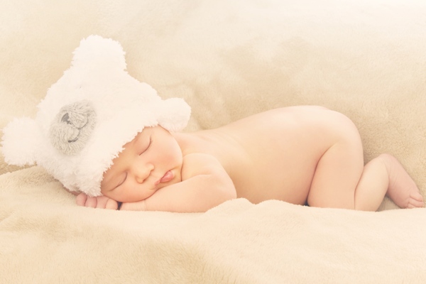 带毛绒帽子趴着睡觉的婴儿图片