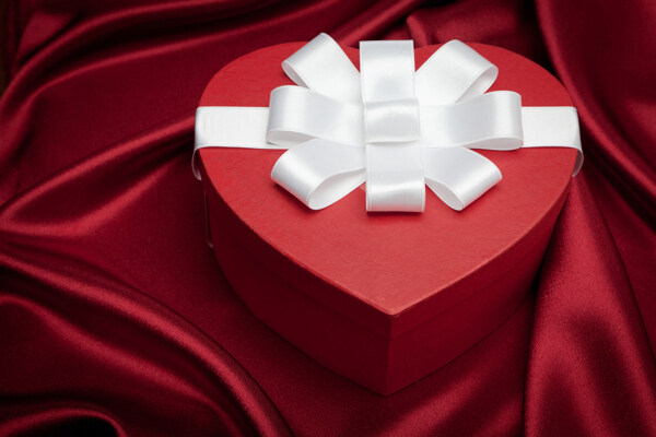 红色爱心礼盒与缎布背景图片