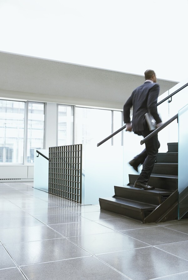 楼梯上奔跑的外国商业男人图片