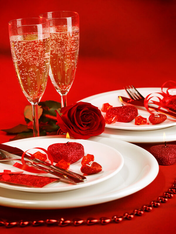 红色桌面上的玫瑰花和酒杯