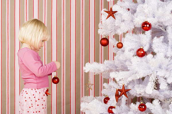 装扮圣诞树的可爱女孩图片