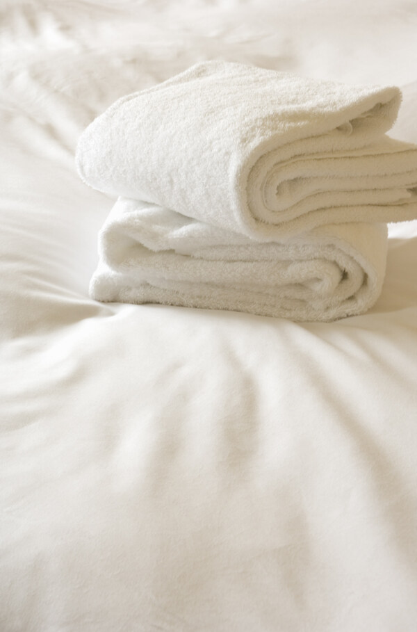 酒店床单上的白色毛巾图片